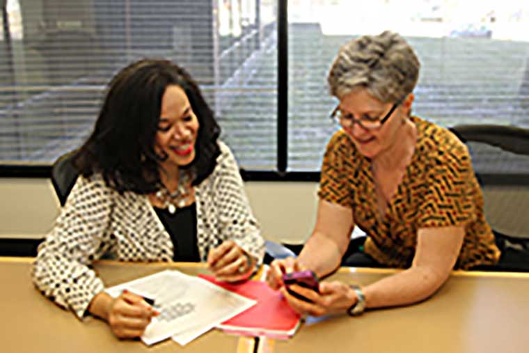 Person A sits with Person B to discuss options in a booklet